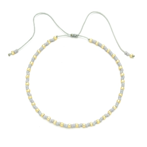 Detail of adjustable gray cord bracelet with matte gray and gold beads in macro view