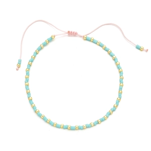 Detail of bohemian handmade beaded bracelet with blue turquoise beads and pink adjustable cord