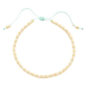 Detail of bohemian handmade beaded bracelet with pink matte beads and gold accents