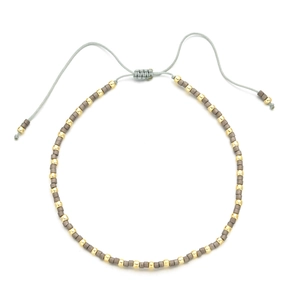 Detail of bohemian handmade beaded bracelet with grey matte beads and gold spacers
