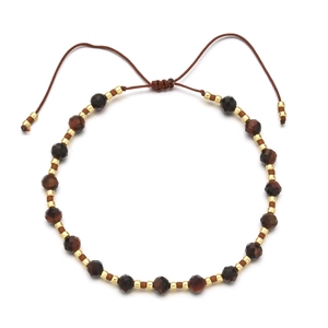 Detail of 4mm faceted brown stones and gold metal beads on an adjustable cord bracelet