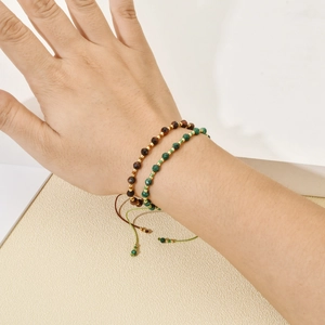 Detail of adjustable bohemian beaded bracelets set with tiger eye and malachite stones
