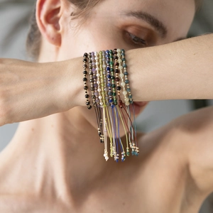 Close-up of stacked bohemian faceted gemstone beaded bracelets on model wrist