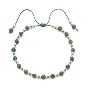 Detailed macro view of bohemian faceted blue stone beads on an adjustable braided cord bracelet