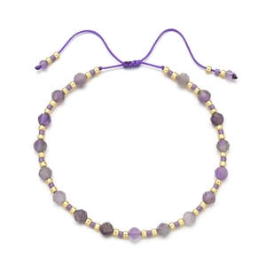 Detail of adjustable purple beaded bracelet with faceted stones and golden metal spacers
