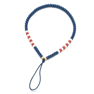 Dettaglio del cinturino per telefono boho con perline blu, bianche e rosse alternate
