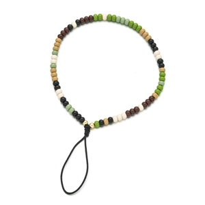 Dettaglio del cinturino per cellulare boho con perline acriliche nei toni della terra
