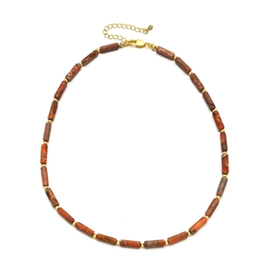 Detail of beaded necklace with blue stone beads and golden metallic bamboo spacers