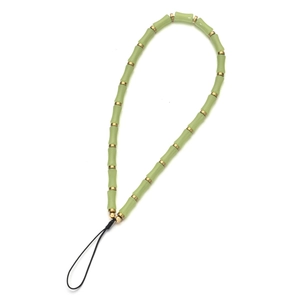 Detail of light green bamboo-shaped resin beads and gold spacer beads on a mobile lanyard