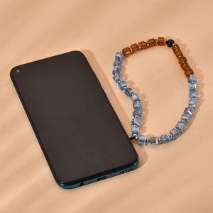 Fashionable blue and amber crystal phone strap with black bead on a dark smartphone