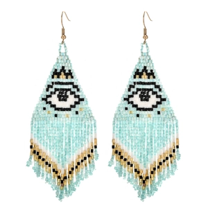 Détail des boucles d'oreilles bohèmes en perles bleues avec motif œil et longs pompons