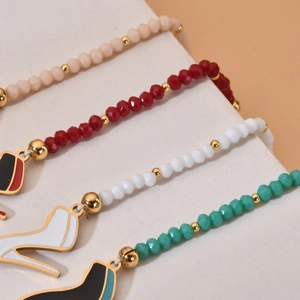 Macro view of colorful beaded bracelets featuring high heel charms and golden beads