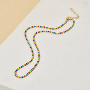 Bohemian rainbow seed bead necklace with gold lobster clasp on clean aesthetic background