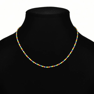 Detailed close-up of bohemian rainbow seed bead necklace on a black mannequin display