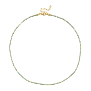 Close-up of golden and turquoise beaded necklace featuring lobster clasp and extension chain