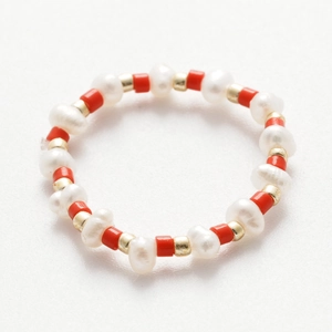 Dettaglio dell'anello fatto a mano con perle d'acqua dolce e perline rosse e dorate