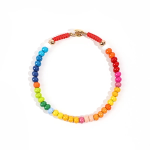 Close-up of a colorful enamel beaded necklace with a golden metallic toggle clasp