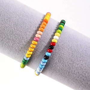 Close-up of colorful enamel beaded bracelets on a grey velvet display roll