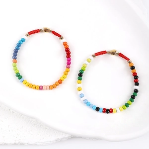 Detail of colorful enamel beaded necklaces with rainbow gradient and red woven cord