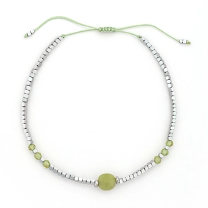 Detail van bohemien geweven armband met groene agaatkralen en zilveren zeshoekige bedels