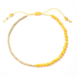 Detalle de la pulsera bohemia de cuentas amarillas con separadores dorados y cordón ajustable