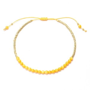 Vista de detalle de pulsera de cuentas amarillas con separadores dorados y cordón
