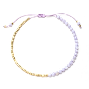 Detalle de pulsera boho de cuentas moradas con acentos dorados y cordón ajustable