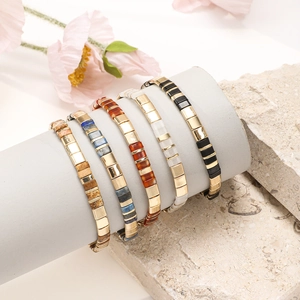 Detail view of five bohemian Tila bead bracelets featuring diverse color palettes and metal spacers
