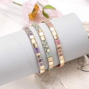 Detail showing vintage ethnic Tila beads bracelets in purple, green and pink stones
