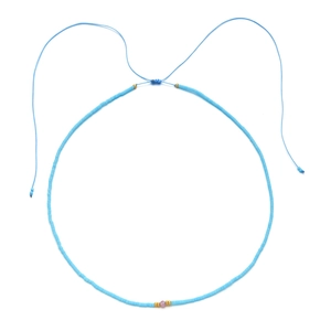 Detail of handmade blue beaded necklace with golden accents and adjustable drawstring cord