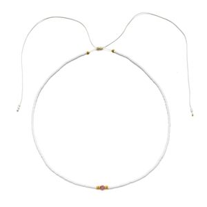 Detail of handmade beaded necklace featuring white seed beads with a pink accent bead