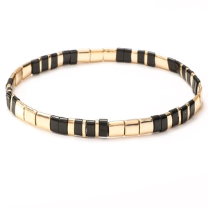Handmade vintage bohemian Tila bead bracelet featuring black and gold elastic design