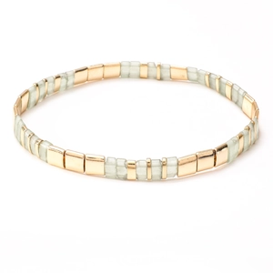 Detail of vintage Tila bead bracelet with green tiles and golden metal spacers