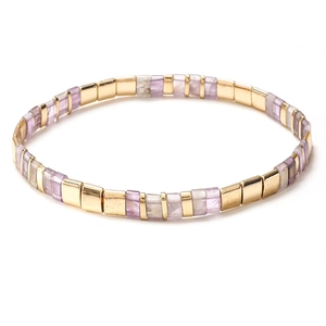 Close-up of handmade Tila bead bracelet with golden metal and purple square stones
