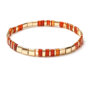 Detail view of retro Tila bead bracelet with golden and orange enamel square tiles