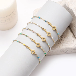 Detail von fünfteiligem Herz-Schlüssel-Armbandset mit bunten Emaille-Perlen in Gold