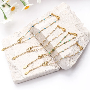 Goldenes Edelstahl-Herz-Schlüssel-Armband mit bunten Perlen auf einem Naturstein-Hintergrund