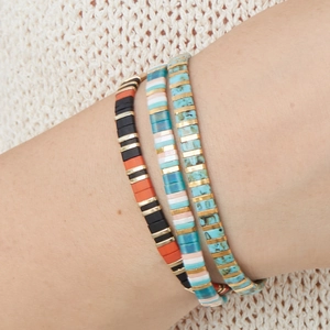 Lot de trois bracelets bohèmes en perles Tila avec accents turquoise et dorés au poignet