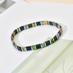 Vue détaillée du bracelet en perles Tila avec mosaïque colorée et entretoises dorées