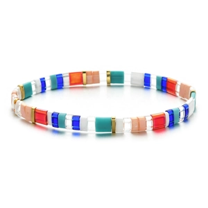 Gros plan de perles Tila colorées et entretoises dorées sur un bracelet élastique