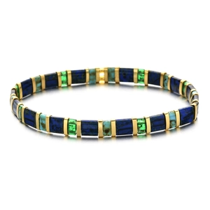 Détail d'un bracelet en perles Tila colorées avec intercalaires dorés et texture