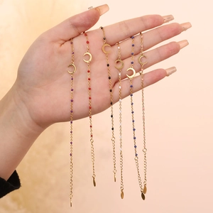 Detail of six adjustable gold stainless steel bracelets with moon charms and colored beads