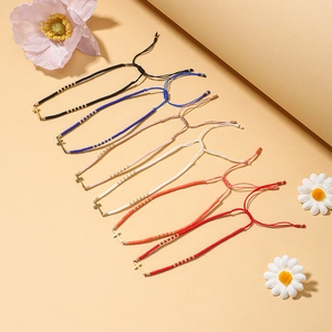 Detalle de seis pulseras de cuentas de colores con colgantes de cruz ajustables