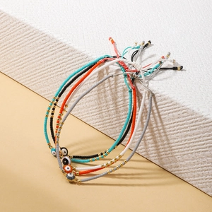 Detalle de 5 pulseras artesanales de mal de ojo con cuentas y cordón ajustable