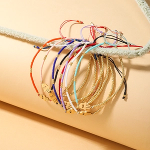 Detailed shot of multi-colored beaded Hamsa Hand bracelets on a natural plant branch