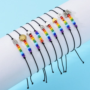 Set di nove bracciali intrecciati neri con perline arcobaleno e ciondoli vari