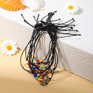 Vista dettagliata di braccialetti intrecciati con ciondoli a forma di conchiglia e farfalla