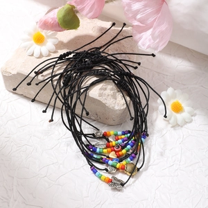 Dettaglio di braccialetti colorati in perline Miyuki con ciondoli su pietre naturali