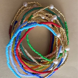 Set de pulseras de cuentas de colores bohemias multicapa con perlas sobre fondo dorado