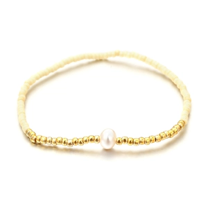 Pulsera elástica bohemia con cuentas de color crema y perla blanca central brillante